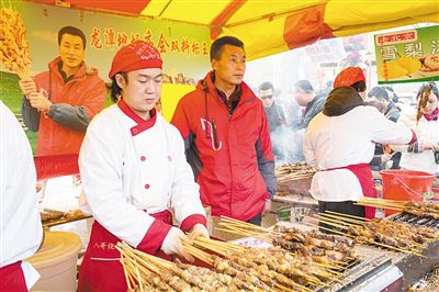 賣羊肉串?dāng)偽焕习遐w山（穿紅衣者）。新京報(bào)記者