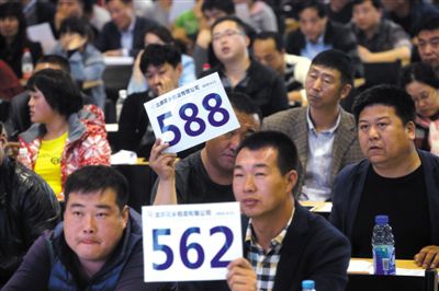 昨日，拍賣現(xiàn)場競拍者舉牌競拍。新京報記者