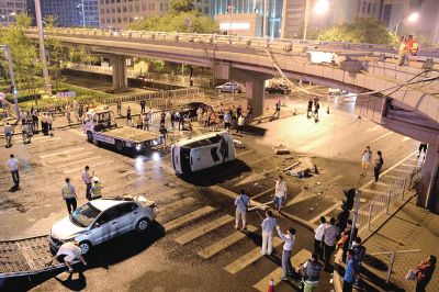 路虎沖下國貿橋砸中一輛起亞轎車，橋上厚達幾十厘米的水泥護欄被撞斷，碎石四處散落，數十群眾在現場圍觀。