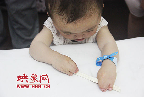 孩子握著筷子發(fā)呆。