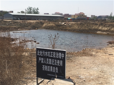 化肥廠滲坑的三分之一經(jīng)過治理，但水質(zhì)仍然呈黃褐色。