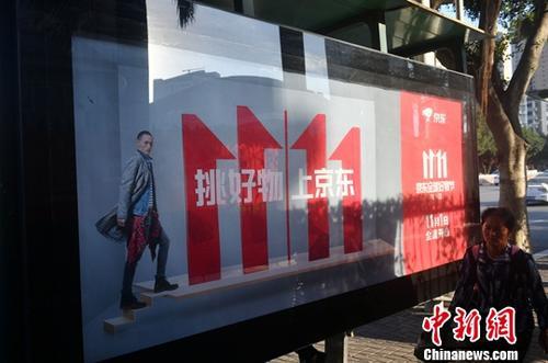 資料圖：11月1日，福州民眾從雙十一廣告牌前經(jīng)過。中新社記者 呂明 攝