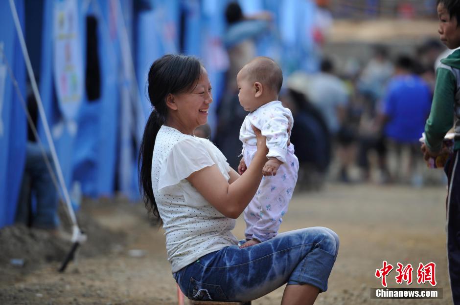 8月6日，一名年輕的母親在和孩子玩樂。