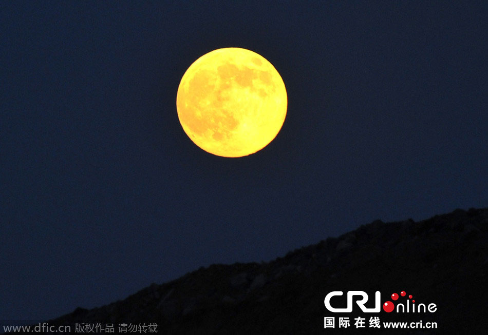 8月10日晚，一輪金燦燦的大月亮在遼寧省大連市東方升起。圖片來源：劉德斌/東方IC