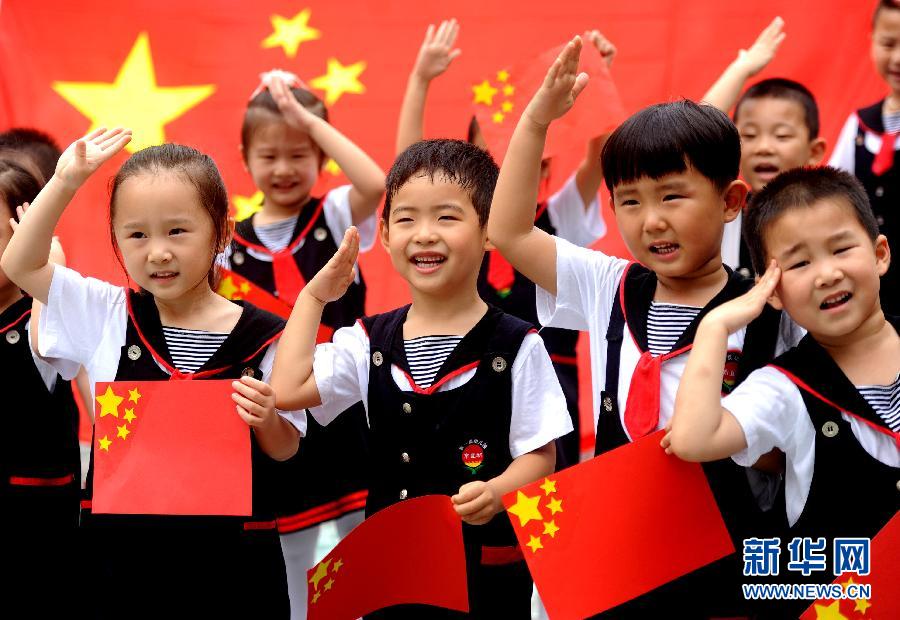  9月28日，安徽淮南市直機關(guān)幼兒園的小朋友在國旗前唱《國歌》，慶祝祖國65周歲生日。