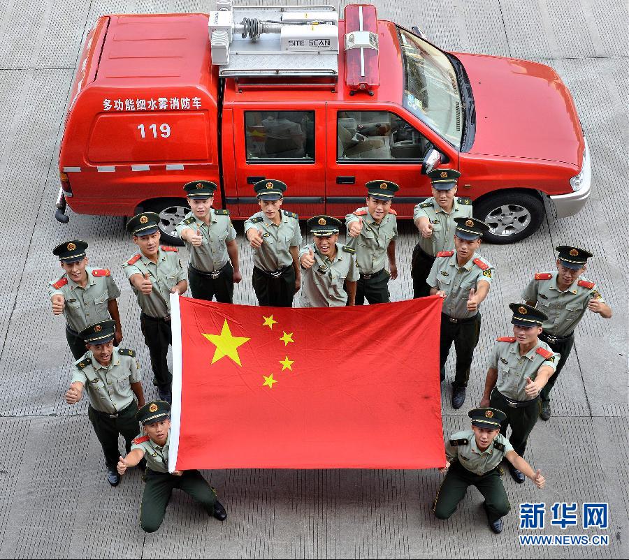  9月25日，武警浙江嘉興消防官兵與國旗合影。