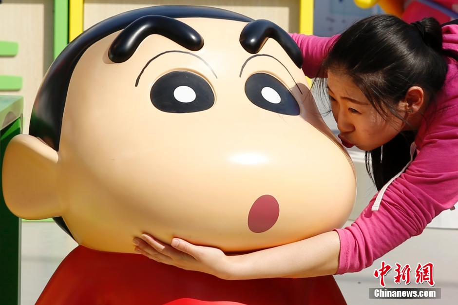 4月22日，游客與蠟筆小新合影?！跋灩P小新25周年紀(jì)念特展”日前在北京開展，吸引了不少市民游客。