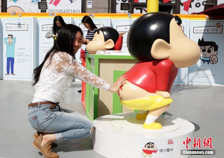 4月22日，游客與蠟筆小新合影?！跋灩P小新25周年紀(jì)念特展”日前在北京開展，吸引了不少市民游客。