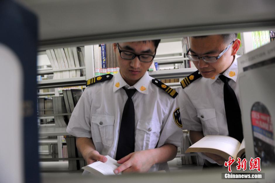 5月8日，武漢輕工大學(xué)圖書館保安吳濤與江力在圖書館交流學(xué)習(xí)。