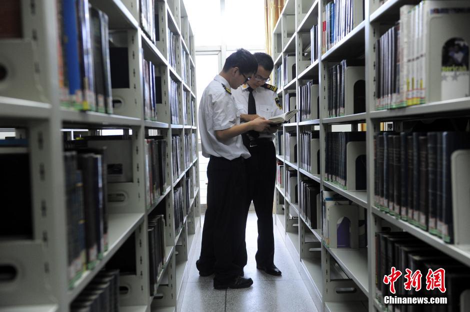 5月8日，武漢輕工大學(xué)保安吳濤與江力在圖書館交流學(xué)習(xí)。中新社發(fā) 張暢 攝
