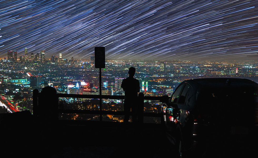 照片中，一名男子看著流星和隕星劃過天空。（網(wǎng)頁截圖）
