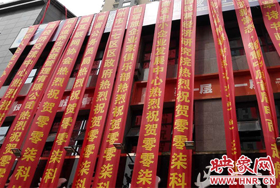 路邊一棟樓上懸掛著二三十條紅色條幅，全部是祝賀一家公司開業(yè)的。