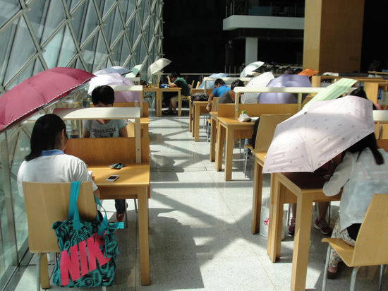 2015年8月2日，深圳圖書館，“太陽曬進(jìn)來很熱的，我們都要撐著傘讀書。”