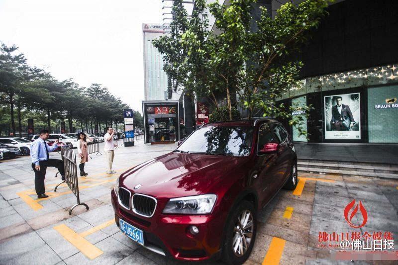 一輛停在停車位上的寶馬轎車，被墜落的樹枝砸中，樹枝徑直插入車內(nèi)，現(xiàn)場引發(fā)不少市民圍觀拍照。