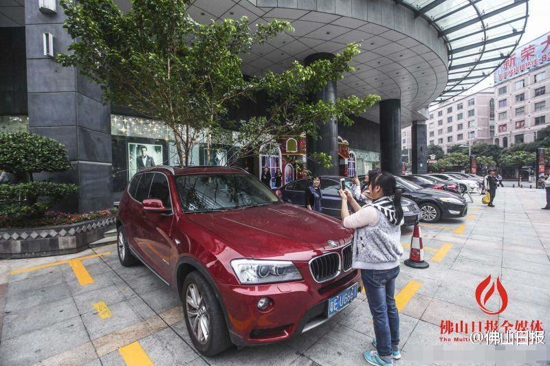 一輛停在停車位上的寶馬轎車，被墜落的樹枝砸中，樹枝徑直插入車內(nèi)，現(xiàn)場引發(fā)不少市民圍觀拍照。