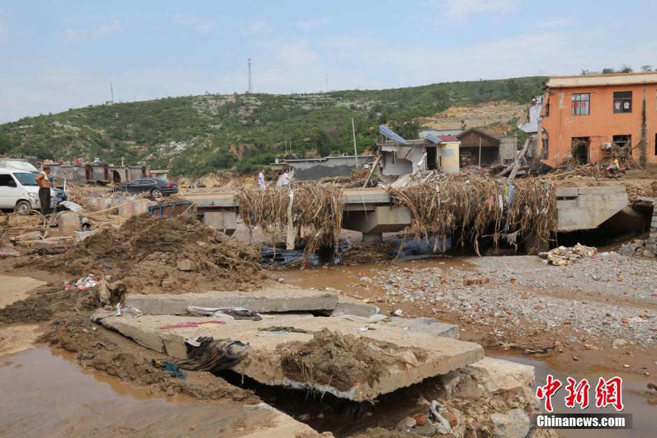 圖為洪水過后，坍塌的橋梁上遺落大量雜草。