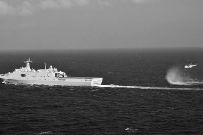 11日，抵達馬航飛機失聯(lián)海區(qū)的海軍井岡山艦與艦載直升機協(xié)同展開立體搜救行動。新華社發(fā)