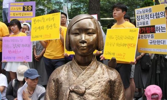 7月2日，在韓國首爾的日本駐韓國大使館前，民眾在慰安婦少女像旁手持標語參加抗議活動。
