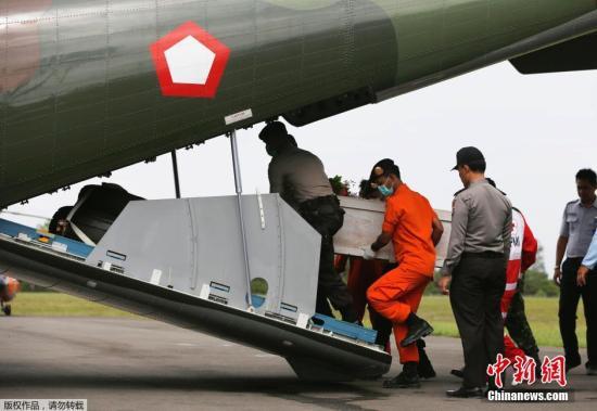 資料圖：當?shù)貢r間2015年1月19日，印尼龐卡蘭布翁，依斯干達空軍基地，救援隊成員正將裝有亞航失事飛機遇難者尸體的棺材抬上一架CN2950運輸機。