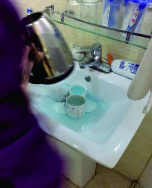 酒店服務(wù)員用潔廁液刷燒水壺和茶杯。
