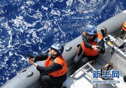 　3月28日，十余名臨檢拿捕隊員乘小艇駛至模擬可疑商船下方水面。
