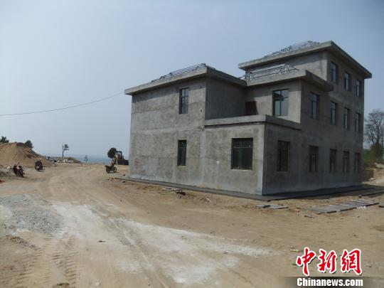 鴨河水庫庫區(qū)邊的新建別墅，一面墻上寫著“拆”，另一邊在加緊施工。吳揚(yáng)　攝