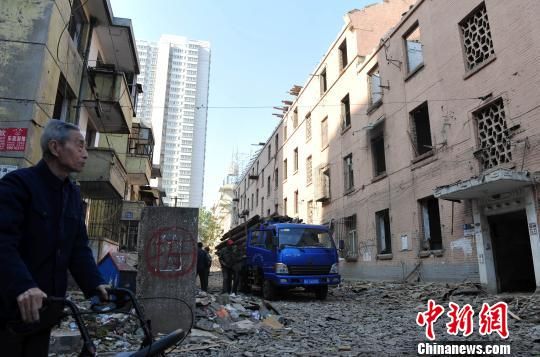 一位花甲老人站在即將拆除的樓房旁，默默地與“蘇聯(lián)樓”告別。　翟羽佳　攝