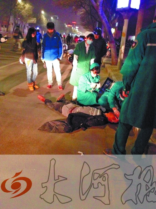 醉漢躺在地上，醫(yī)護人員對其進行檢查。
